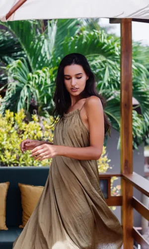 mujer-sonriente-positiva-bastante-europea-vestido-vuelo-verano-luz-natural-dia-terraza-villa-disfrutando-hermosas-vacaciones-sofa-al-aire-libre-almohadas-tropical
